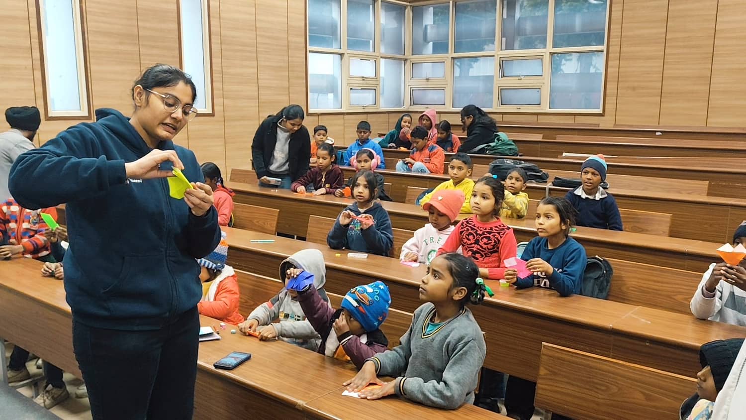 Triman leading a hands-on activity with children in a classroom